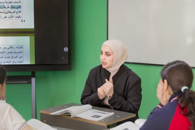معلمة تشرح الدرس باستخدام السبورة الذكية